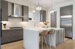 Experience modern luxury in this stunning kitchen, featuring sleek grey cabinetry and a gleaming stainless steel range hood.