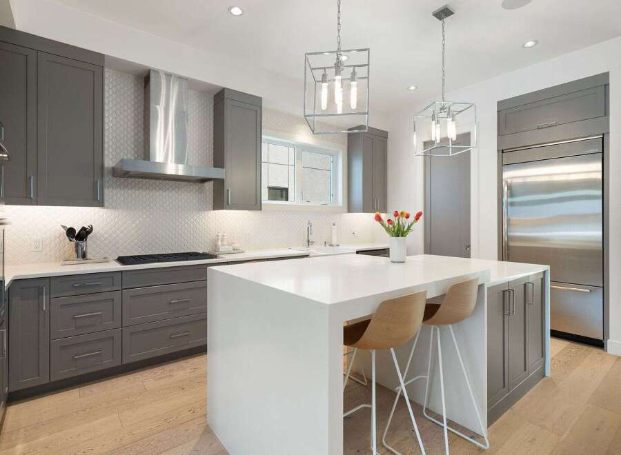 Experience luxury in this modern kitchen featuring sleek grey cabinetry and a stunning white quartz island.