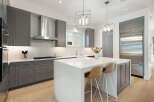 Experience luxury in this modern kitchen featuring sleek grey cabinetry and a stunning white quartz island.