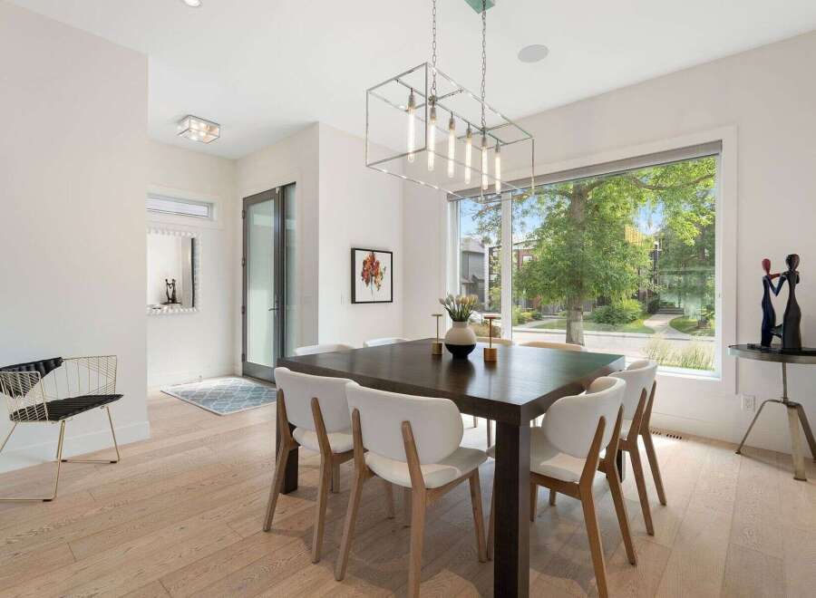 Experience elegant dining in this beautifully appointed space, featuring a dark wood table surrounded by chic white chairs.