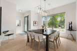 Experience elegant dining in this beautifully appointed space, featuring a dark wood table surrounded by chic white chairs.