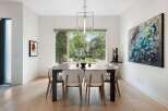 Experience elegant dining in this beautifully appointed space, featuring a large dark wood table surrounded by modern white chairs.