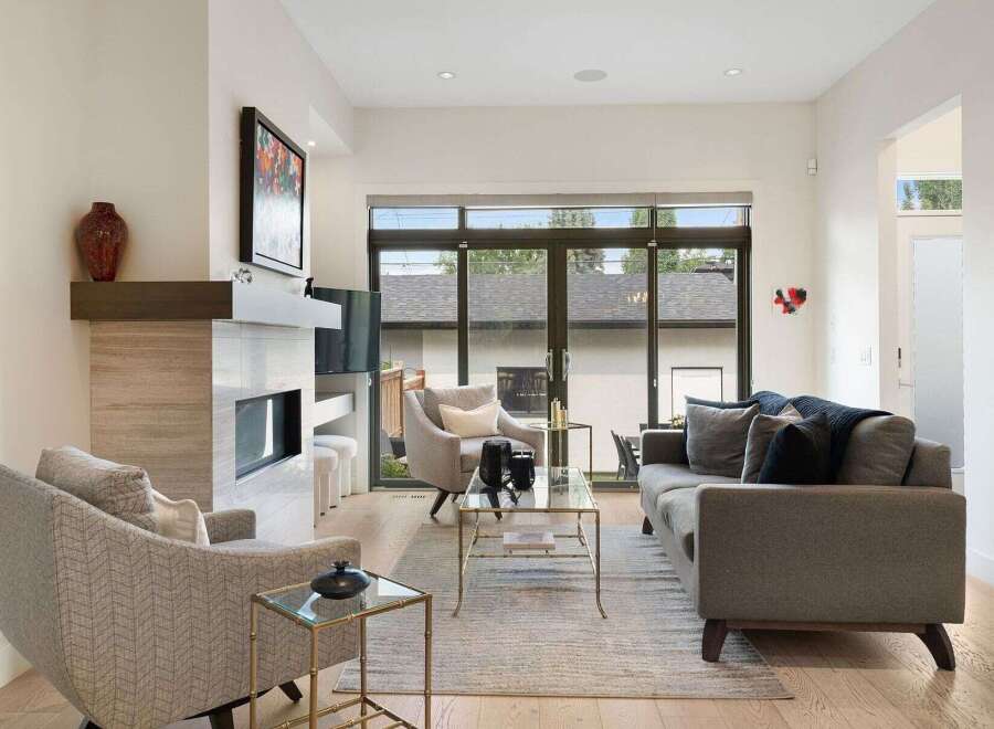 Experience modern living in this stunning living room, featuring a sleek fireplace and expansive sliding glass doors that open to a private backyard.