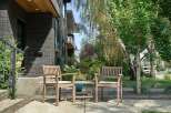 Enjoy your morning coffee on the charming front porch, complete with two wooden chairs and a small table, perfect for outdoor relaxation.