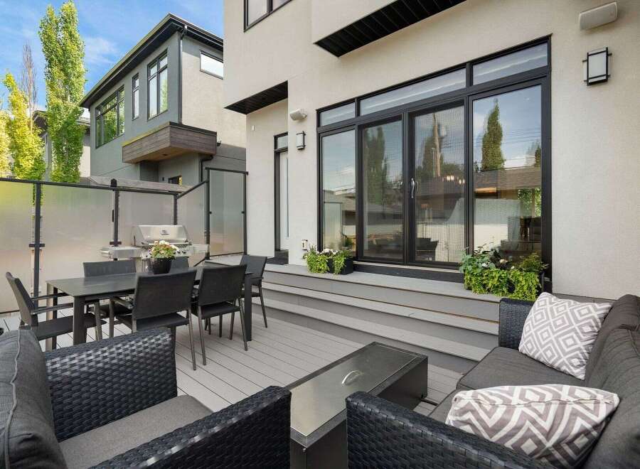 Experience seamless indoor-outdoor living with this modern backyard oasis, featuring a spacious deck perfect for entertaining.