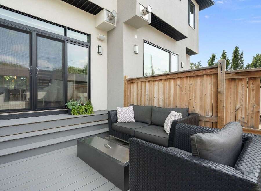 Enjoy outdoor living on this modern deck featuring comfortable seating and a sleek fire pit.