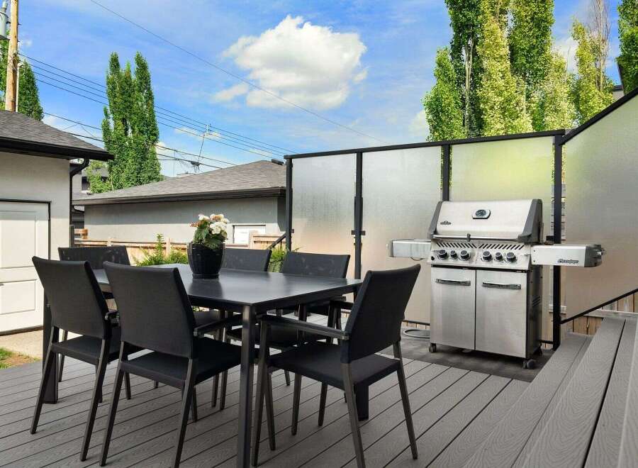 Enjoy outdoor living with this spacious deck featuring a dining set and a premium grill, perfect for entertaining.