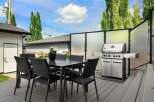 Enjoy outdoor living with this spacious deck featuring a dining set and a premium grill, perfect for entertaining.