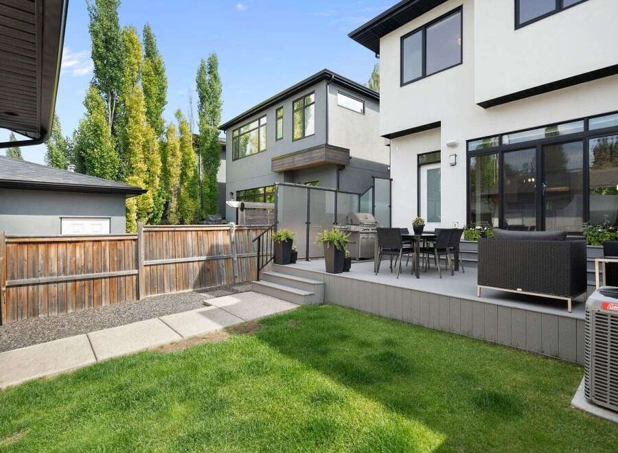 Experience modern luxury in this stunning backyard oasis, featuring a spacious deck perfect for entertaining.