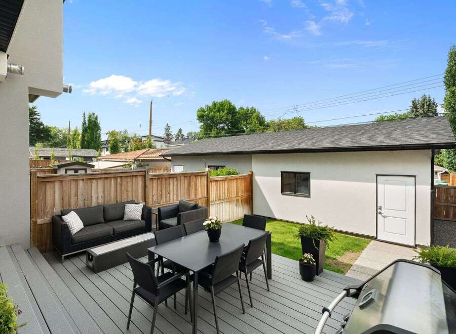 Enjoy outdoor living at its finest with this spacious deck featuring a modern dining set and comfortable lounge area, perfect for entertaining guests.