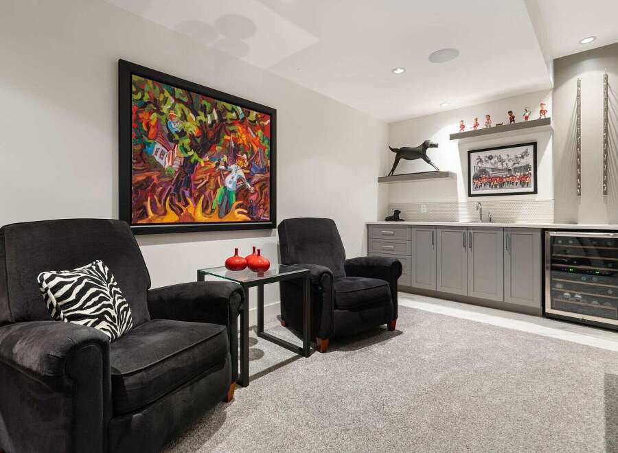 Experience sophisticated relaxation in this modern living space, featuring plush charcoal recliners perfect for unwinding.