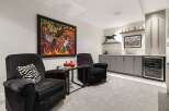 Experience sophisticated relaxation in this modern living space, featuring plush charcoal recliners perfect for unwinding.