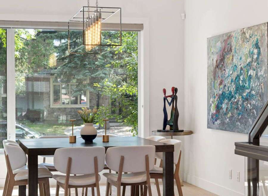 This elegant dining room features a modern dark wood table surrounded by plush white chairs, perfect for hosting guests.