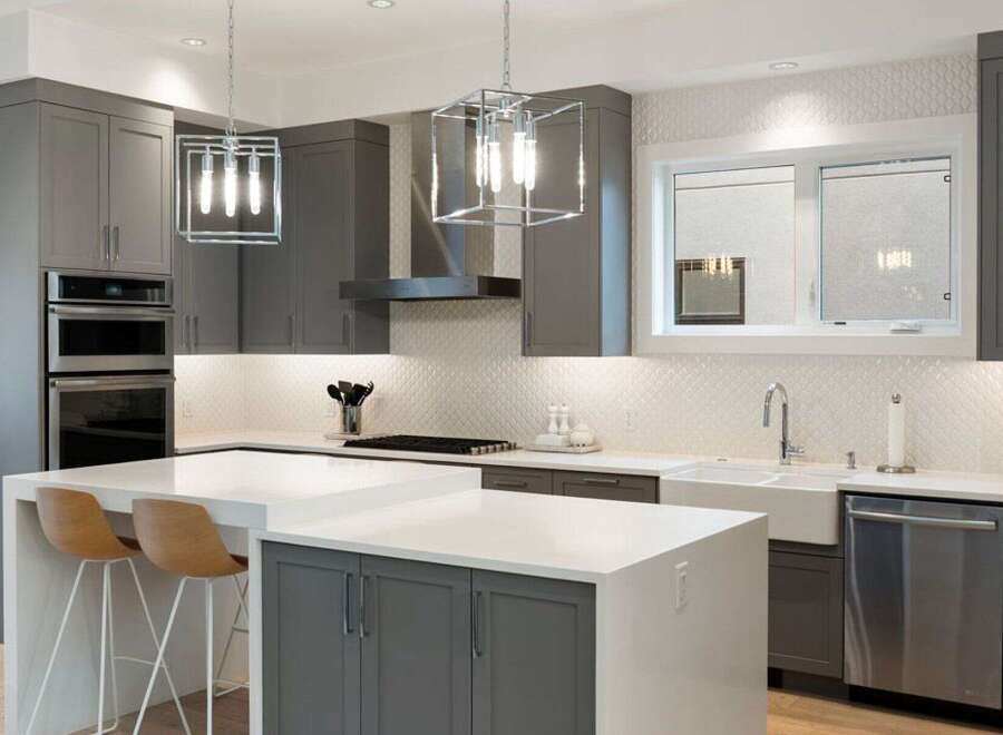 Experience modern luxury in this stunning kitchen, featuring sleek grey cabinetry and a spacious quartz island perfect for entertaining.