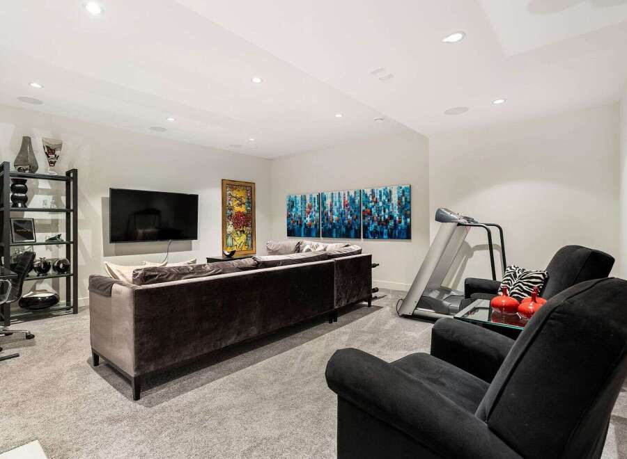 This modern living space features a plush sectional sofa perfect for relaxation, complemented by a large flat-screen TV for entertainment.