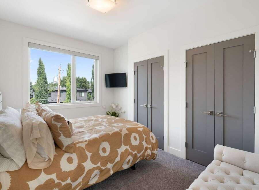 This inviting bedroom features a large window offering scenic views and ample natural light.