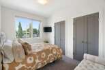 This inviting bedroom features a large window offering scenic views and ample natural light.
