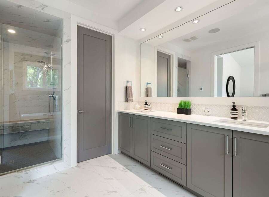 Experience modern luxury in this stunning bathroom, featuring a spacious glass-enclosed shower with marble tile accents and a sleek, floating vanity with ample storage.