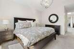 This inviting bedroom features a spacious dark wood bed adorned with a stylish floral duvet and plush pillows.