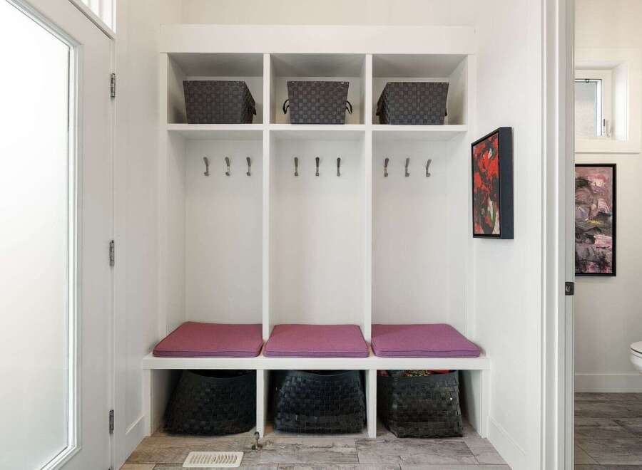 This inviting entryway features a built-in mudroom bench with ample storage, perfect for organizing shoes and accessories.