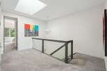 Experience modern luxury in this stunning home featuring a bright and airy upper hallway with a large skylight.