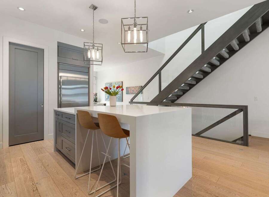 Experience modern living in this stunning kitchen featuring a sleek white island with bar seating, perfect for casual dining and entertaining.