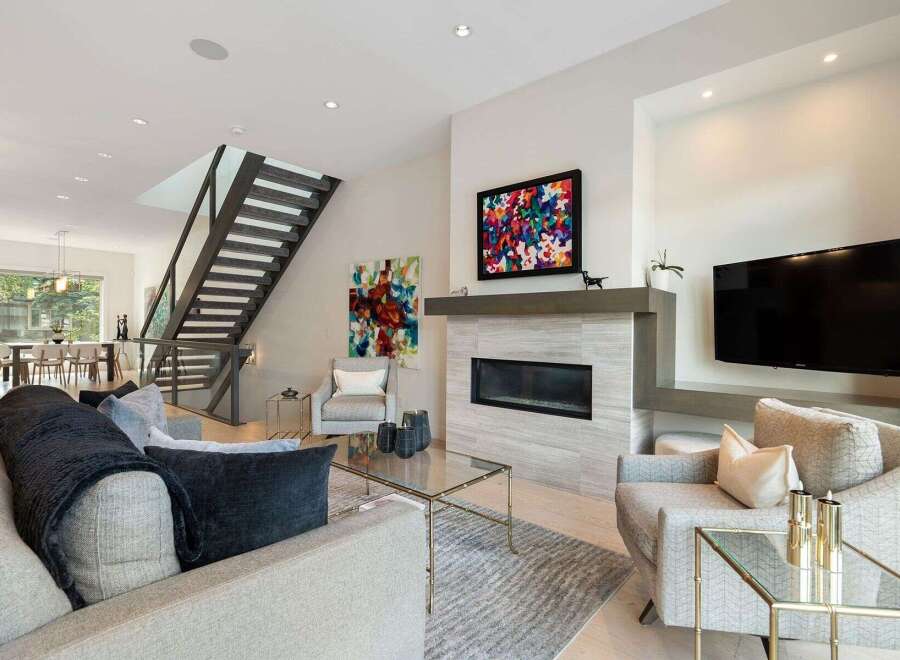 Experience modern luxury in this stunning living room featuring a sleek fireplace and a vibrant abstract artwork.