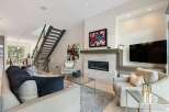 Experience modern luxury in this stunning living room featuring a sleek fireplace and a vibrant abstract artwork.