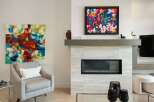 Experience modern living with this stunning living room featuring a sleek fireplace and vibrant abstract art.
