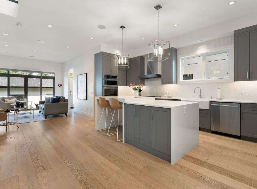 Experience modern living in this stunning open-concept home, featuring a sleek grey gourmet kitchen with a large island and top-of-the-line appliances.