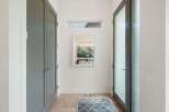 Step into this elegant entryway featuring a sleek grey double door closet and a modern glass door leading outside.