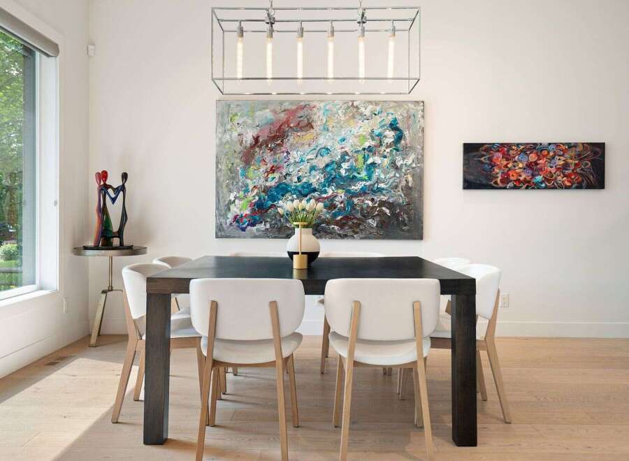 This elegant dining room features a large abstract painting above a dark wood dining table, complemented by modern white chairs.