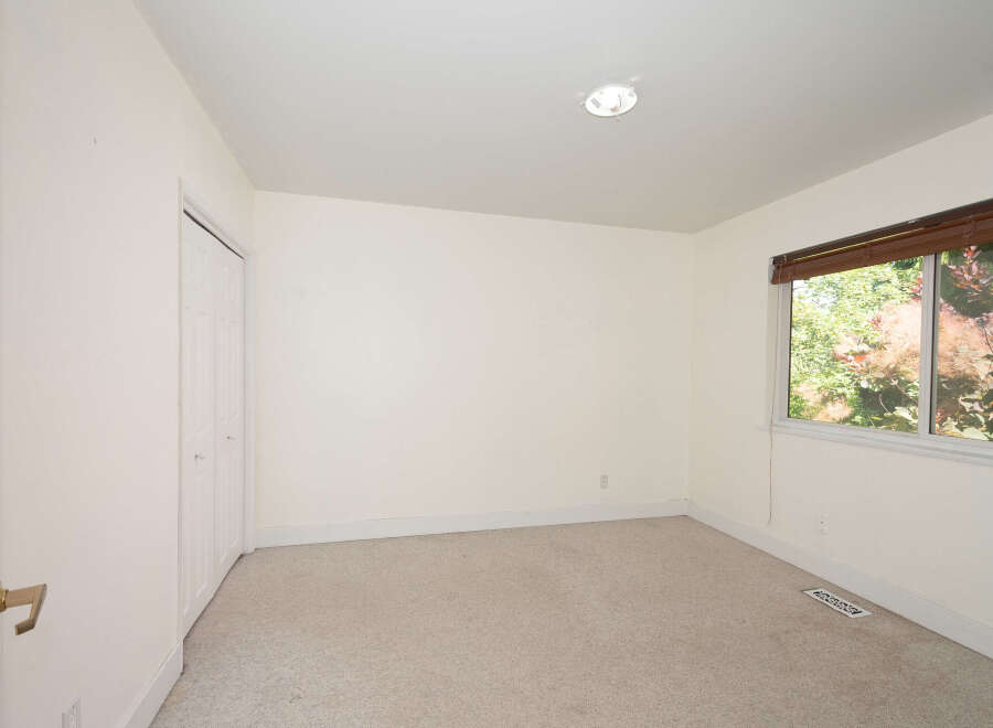 This empty room features neutral-toned carpeting and walls, creating a blank canvas for your personal style.