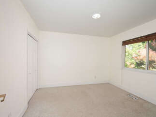 This empty room features neutral-toned carpeting and walls, creating a blank canvas for your personal style.