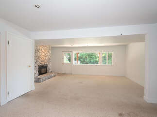 Discover comfort and style in this spacious living area, featuring a striking stone fireplace as the focal point.