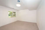 This spacious room features a large window offering abundant natural light and views of lush greenery.