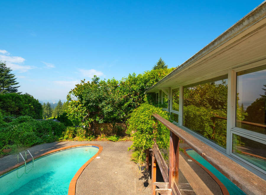 Enjoy a refreshing dip in the sparkling pool, surrounded by lush greenery and mature trees.
