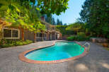 Escape to your private oasis with this stunning backyard featuring a sparkling kidney-shaped pool, perfect for summer relaxation and entertaining.