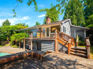 Enjoy outdoor living with this charming home featuring a spacious wooden deck and a sparkling swimming pool, perfect for entertaining or relaxing.