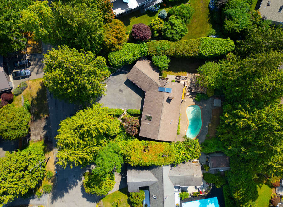 Discover this stunning aerial view showcasing a luxurious property with a private swimming pool and expansive green spaces.