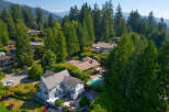 Nestled amidst lush greenery and towering trees, this stunning property offers a private oasis with a sparkling swimming pool and expansive outdoor living spaces.