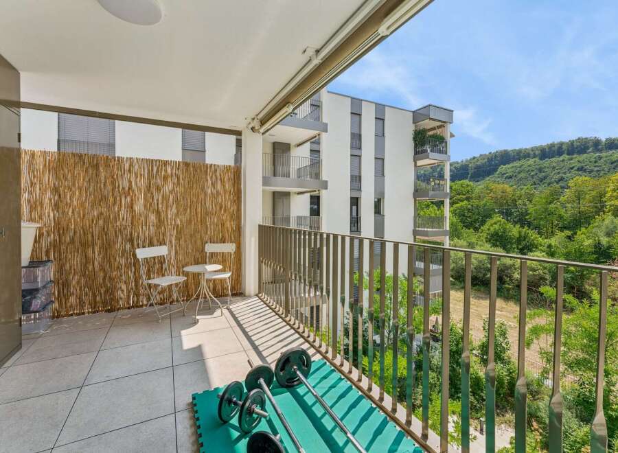 Enjoy your morning coffee on this spacious balcony, complete with a charming bistro set and a convenient storage cabinet.