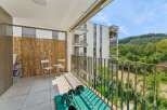 Enjoy your morning coffee on this spacious balcony, complete with a charming bistro set and a convenient storage cabinet.