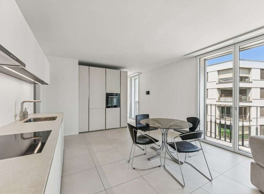 Experience modern living in this sleek apartment featuring a contemporary kitchen with integrated appliances and a stylish dining area.