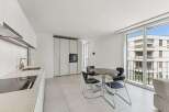 Experience modern living in this sleek apartment featuring a contemporary kitchen with integrated appliances and a stylish dining area.
