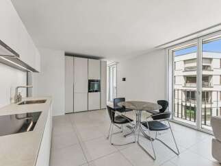 Experience modern living in this sleek apartment featuring a contemporary kitchen with integrated appliances and a stylish dining area.