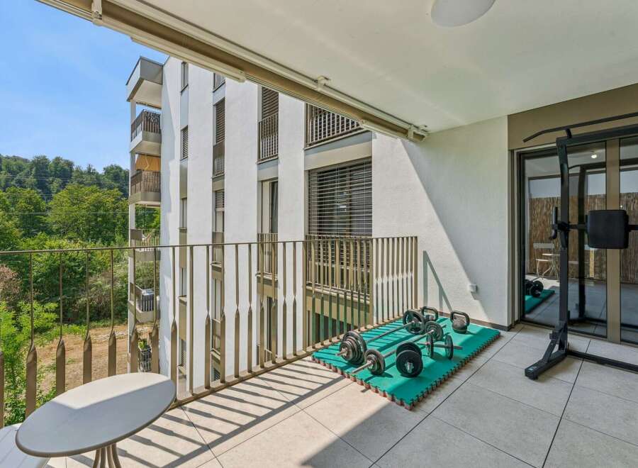 Enjoy your personal fitness sanctuary on this spacious balcony, complete with a weight rack, dumbbells, and kettlebells.