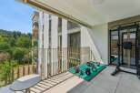 Enjoy your personal fitness sanctuary on this spacious balcony, complete with a weight rack, dumbbells, and kettlebells.