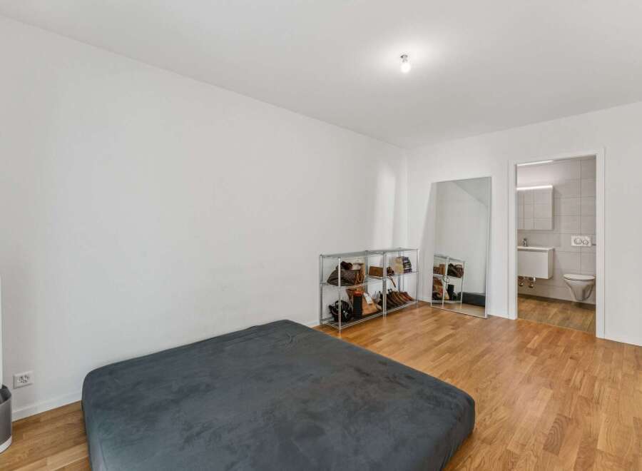 This modern bedroom features a comfortable bed and a sleek Dyson fan for optimal climate control.