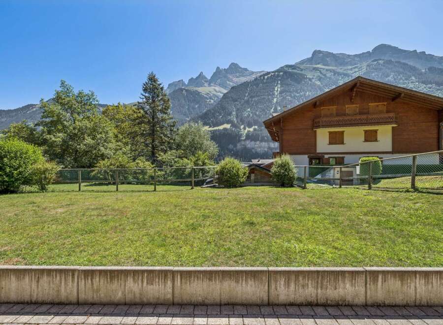 Nestled against a backdrop of majestic mountains, this charming wooden chalet offers a serene retreat.